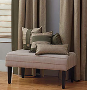 Beautiful curtains and pillows on table in color taupe